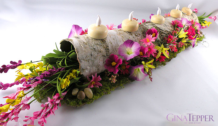 Birch Log filled with spring flowers with candles on top