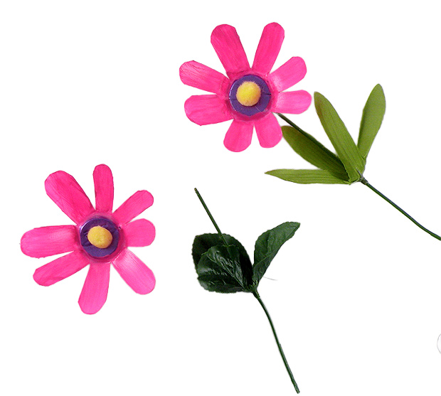Handmade pink flowers created from upcycled plastic water bottles. The design features hand-cut petals, a yellow pom-pom center, and realistic green leaves, demonstrating a high-end upcycling hack by Gina Tepper.