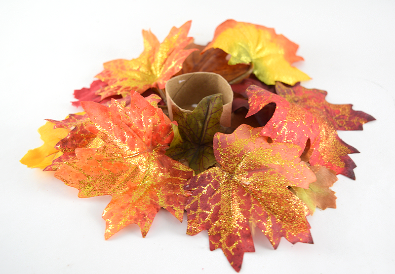 DIY Candle ring centerpiece attaching fall leaves to the base