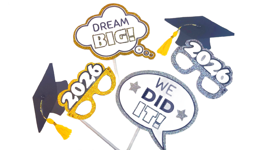 Set of DIY glittery graduation photo booth props including graduation caps, 2026 glasses, and Dream Big signs for a Class of 2026 celebration.