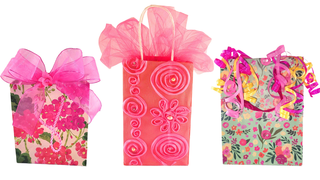 Seven gift bag filler ideas. Three pink and red decorated gift bags showing creative tissue paper alternatives like a large sheer bow, airy tulle, and festive curling ribbon.