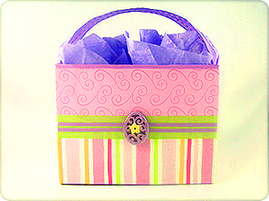 Boutique DIY gift basket crafted from cardstock, featuring pink striped paper, lime green ribbon, and an ornamental egg center embellishment.