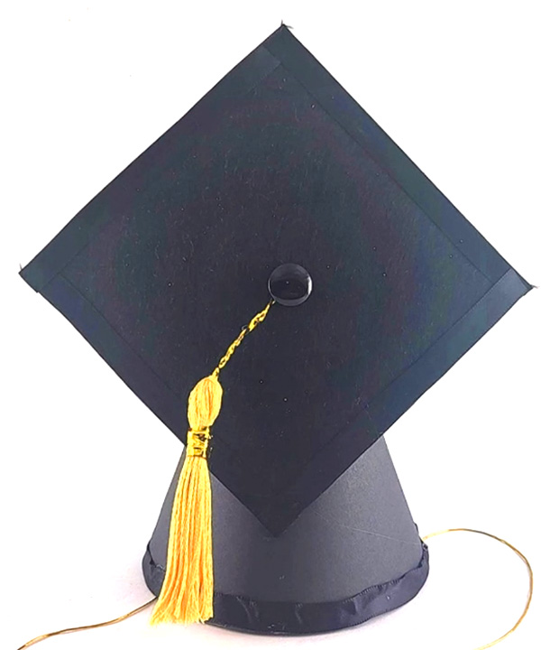 Black graduation cap with yellow tassel used for DIY graduation party decor.