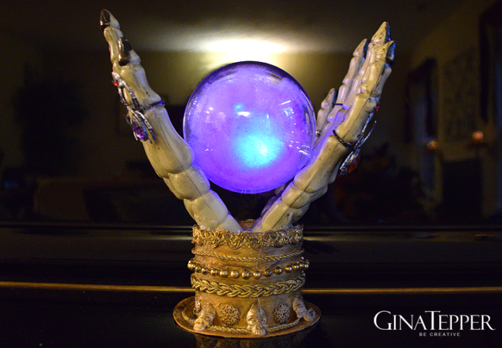 glowing crystal ball held by hands and a crystal ball stand