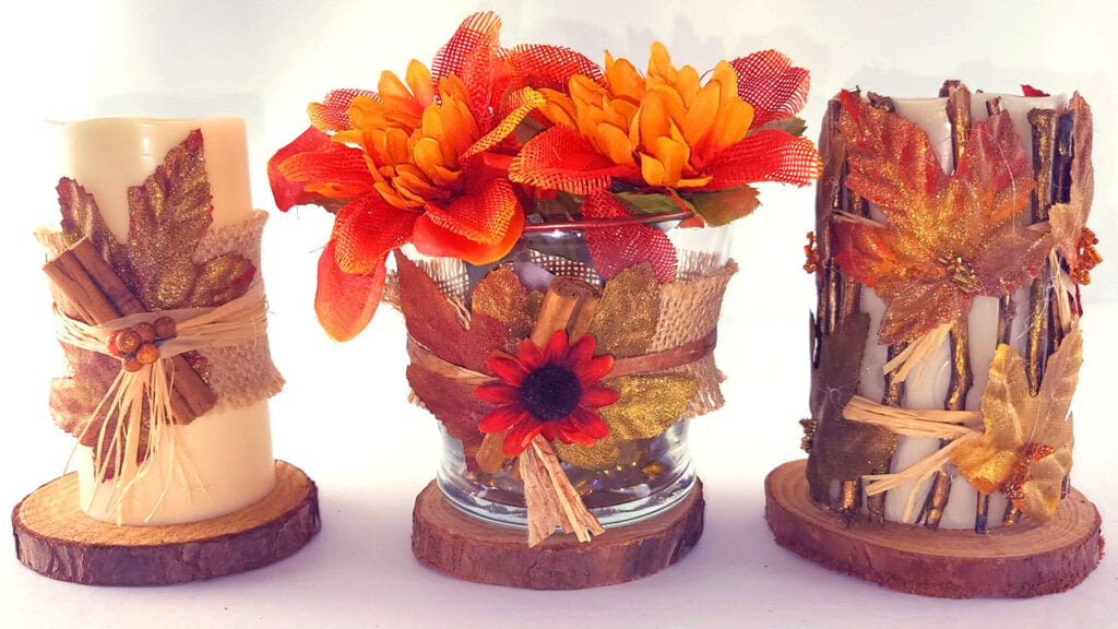 Three decorated fall candles made with Dollar Tree supplies, including a floral candle centerpiece, a painted leaf candle, and a rustic twig-wrapped candle.
