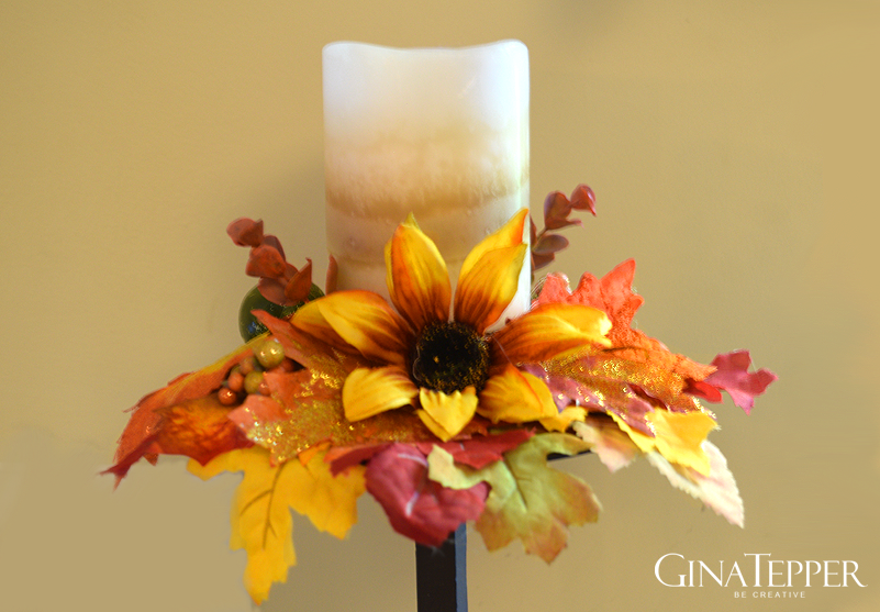 Dollar Tree fall candle ring made with autumn florals that stabilizes a candle on a spike.