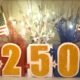 Patriotic July 4th centerpiece featuring glittery “250” numbers, American flags, and red, white, and blue streamers arranged on a festive display.