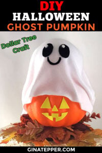 A small foam pumpkin covered with a white ghost cloth, decorated with black eyes and a smiling mouth, sitting on fall leaves as a cute no‑carve Halloween craft.