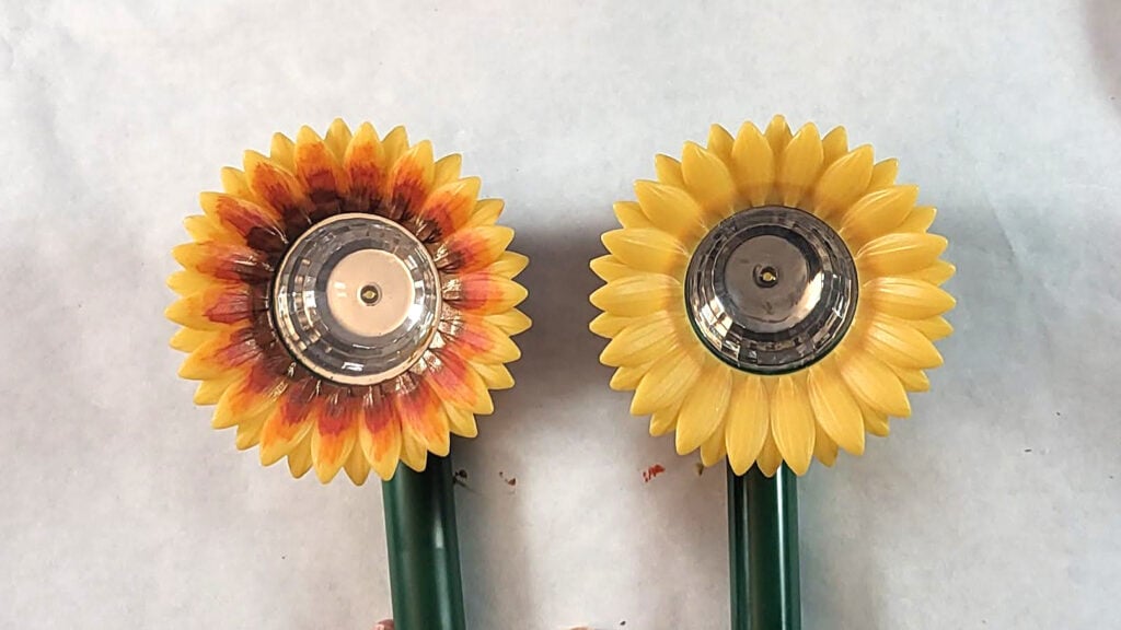 Two sunflower solar lights showing different painted designs
