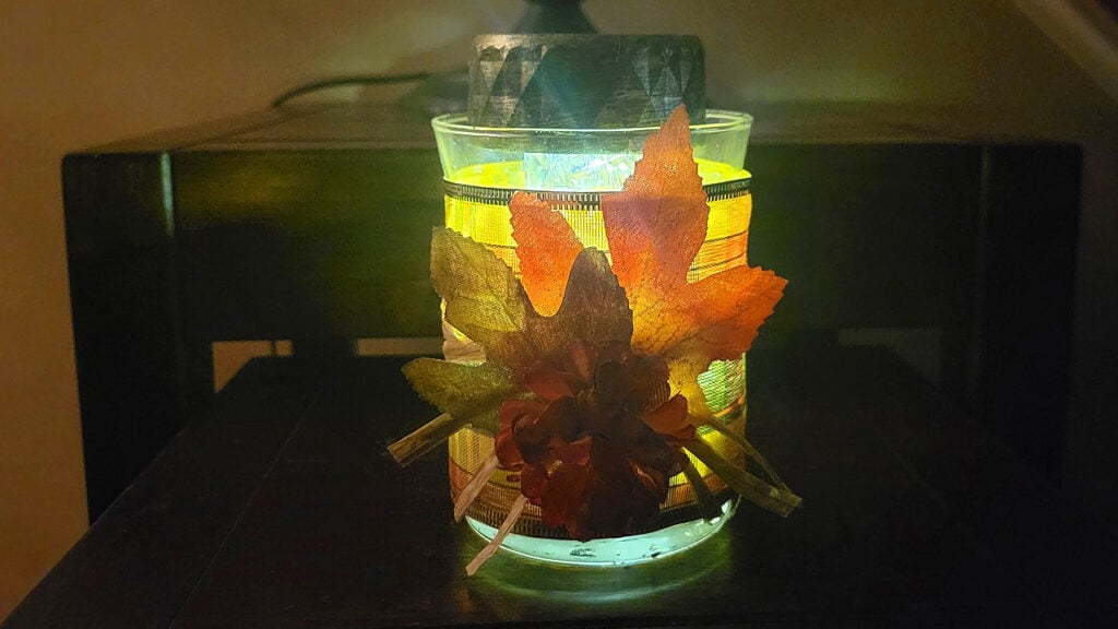Fall leaf glow jar with illuminated autumn leaves inside a glass container, styled as cozy Dollar Tree fall decor.